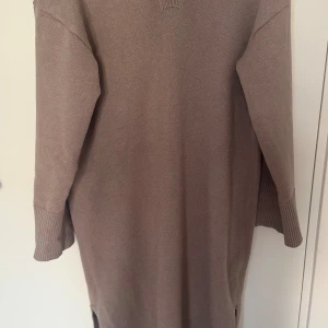 Beige stickad tröja från Bik Bok - Säljer en beige stickad tröja från Bik Bok i storlek XS. Tröjan har en v-ringad design och långa ärmar med ribbade muddar. Perfekt för kyligare dagar med sin mjuka och bekväma passform. Klänningen är oversize och kan därför passa allt från XS-M 