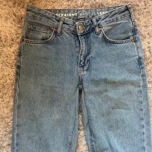 Blå jeans med rak passform - Säljer ett par klassiska blå jeans med rak passform. De har en knappgylf och femficksdesign. Perfekta för en avslappnad stil. Dom är midwaist men nedsydda ca 3cm så skulle säga att de är mer lowwaist nu! (Man ser att dom är nedsydda men de är inget som märks eller syns när man har dom på sig)😊