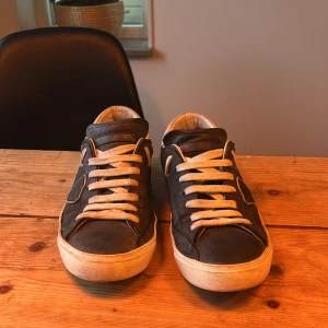 Svarta sneakers med vita detaljer - Snygga mörkblåa sneakers med vita snören och detaljer. Skorna har en rund tå och en bekväm passform. Perfekta för en avslappnad stil.                      Box ingår! Pris kan diskuteras