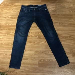 Mörkblå jeans från Replay - Snygga mörkblå jeans från Replay i modellen Anbass. De har en slim fit passform och klassisk femficksdesign. Perfekta för en stilren look.