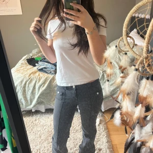 Svarta Low waist jeans - Säljer ett par svarta Low waist jeans med knappar där framme. Nästan aldrig använda och i mycket bra skick!