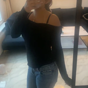 Svart offshoulder långärmad tröja - Säljer en svart långärmad tröja med offshoulder-modell.