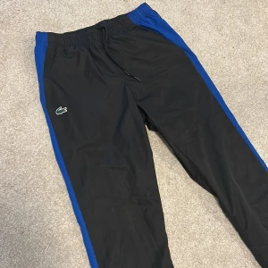 Lacoste byxor  - Säljer ett par coola Lacoste byxor till ett bra pris! Köptes i Lacoste butiken för 1000kr och säljer dom nu för endast 499. Dom är använda ett väldigt fåtal gånger och är i mycket bra skick. Storlek S kan även passa dig som har M. Skriv för intresse !