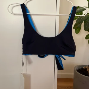 Dubbelsidig bikiniöverdel från COS - Snygg dubbelsidig bikiniöverdel från COS. Modellen har breda axelband, rundad halsringning och knyt i ryggen.