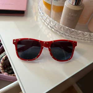 Röda Giiflar solglasögon med mönster - Coola röda solglasögon från Gifflar med svarta glas och ett unikt småmönstrat tryck över hela bågen. Passar både små och stora och killar och tjejer! Unika🥰