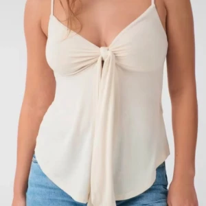 Beige linnetopp med knyt från Gina Tricot - Supersöt beige linnetopp från Gina Tricot med smala axelband och snygg knytning framtill. Toppen har en flowy passform och är tillverkad i mjukt material som känns skönt mot huden. Säljer då det aldrig kommer till användning (helt nytt). Nypris: 260