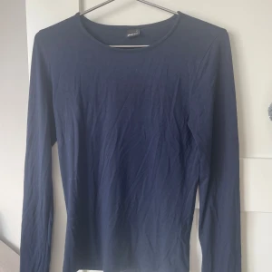 Mörkblå långärmad topp från Gina Tricot - En basic mörkblå långärmad topp från Gina Tricot. Tröjan har rund halsringning och är gjord i mjuk bomull, perfekt att styla med jeans eller kjol. Enkel och stilren modell som funkar året runt. Toppen är i storlek M men funkar också men S Skriv för fler frågor💙