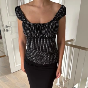 Polkadot blus - Supersöt och trendig blus med polkadot mönster. Modellen har kort puffärm, söt knytning vid bysten och en lätt figursydd passform. Storlek M💓