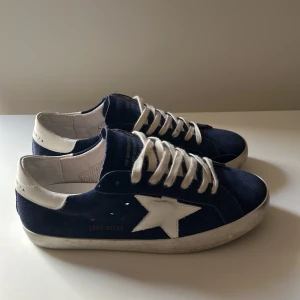 Golden Goose Superstar Skor Navy — Äkthetsbevis finns  - Stilrena Superstar i marinblått. Nästan helt nya med klassiskt slitage från fabrik. ÄKTHETSBEVIS FINNS. Inga tillbehör  Skick: 9/10 Pris kan diskuteras 📦 Skickas eller möts upp