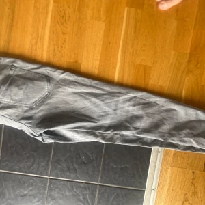 Grå jeans Regular Clark Jack and Jones  29/32 - Snygga grå jeans från Regular Clark/Jack and Jones  i storlek 29/32. Klassisk femficksmodell med raka ben och normal passform. Jeansen har en ljusgrå tvätt och är tillverkade i mjukt jeanstyg som är sköna att bära hela dagen.