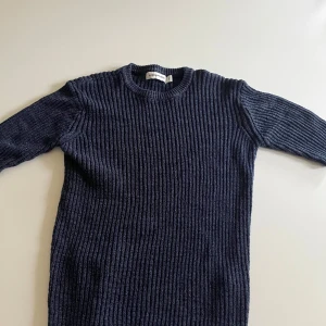 Mörkblå ribbstickad tröja Carin Wester - Ribbstickad mörkblå tröja från Carin Wester i storlek S. Tröjan har medellång ärm, rund halsringning och ett glittrigt inslag i materialet som ger en snygg touch. Inte använd mycket, superbra skick🩷