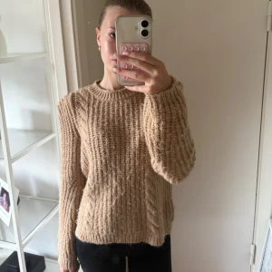 Beige stickad tröja med grov struktur - Supermysig beige stickad tröja med grov ribbad struktur och rund hals. Tröjan har lång ärm och en loose fit som ger en chill vibe. Perfekt att slänga på sig när det är kallt ute. Storlek 152💓