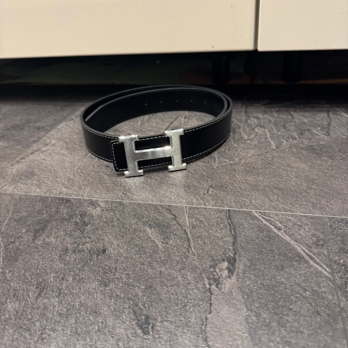 Svart skärp med H-spännee