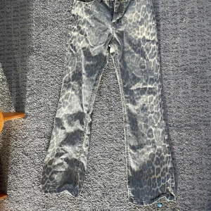 Grå leopardmönstrade bootcut jeans - Säljer ett par grå jeans med leopardmönster och bootcut-snitt. Jeansen e i storlek 152 och är tyvärr för kort för de, De e från sofie schnoor och är köpta för 800🩷