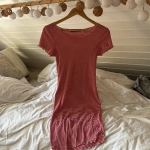 Röd- och vitrandig klänning BikBok XS - Supersöt kortklänning från BikBok i storlek XS. Klänningen är röd och vit med smala horisontella ränder, har korta ärmar och en figurnära passform. Perfekt för en avslappnad och trendig look. Materialet är mjukt och stretchigt för extra komfort.