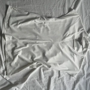 Vit blus - Säljer en stilren vit omlottblus från H&M med v-ringning och korta ärmar. Blusen har en mjuk och lätt struktur, perfekt för en clean och fräsch look. Passar dig som gillar minimalistisk stil och vill ha något enkelt men snyggt.