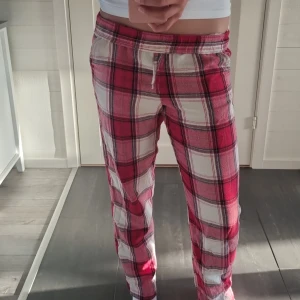 Röd-rutiga mjukisbyxor Kappahl XS - Mysiga mjukisbyxor från Kappahl i rödvitt rutigt mönster. Byxorna har dragsko i midjan och är tillverkade i mjukt bomullstyg.