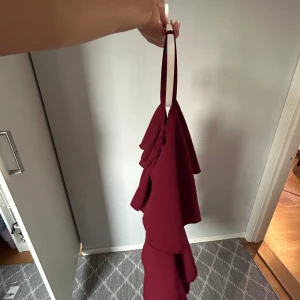 Röd volang klänning  - En jätte fin röd volang klänning. Perfekt att ha till speciella tillfällen. Fick den av en vän så vet ikte vart den är ifrån! 