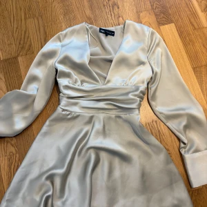 Klänning från Zara - Superfin kort klänning från Zara i storlek Xs. Färgen är en blandning mellan lite grön och champagnefärg. Använd endast en gång och säljer pågrund av att den inte passar mig längre💞