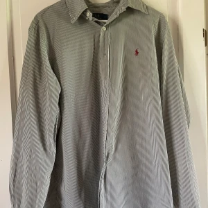 Randig skjorta från Polo Ralph Lauren - Säljer en skjorta från Ralph Lauren. Hör av dig vid frågor, priset kan diskuteras.  🧵 Skick: Mycket bra 📏 Storlek: L 🎨 Färg: Grön, Vit 🏷️ Märke: Ralph Lauren
