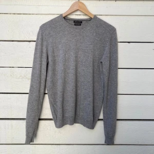 Grå kashmirtröja från Massimo Dutti - Säljer en stilren grå tröja i 100% kashmir från Massimo Dutti. Tröjan har rund halsringning och långa ärmar, perfekt för lager-på-lager eller som den är. Supermjuk och klassisk modell. Väldigt skön och funkar bra på sommaren.