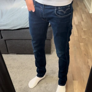Replay Anbass Hyperflex jeans blå - Säljer ett par snygga Replay Anbass Hyperflex jeans i mörkblå denim. Slim passform. Hyperflex är riktigt skönt och stretchigt. Skick 9,8/10 riktigt bra inga defekter eller tecken på användning. Storlek 32/32 passar dig runt 178-190 modellen på bilden är 191 men dem är för korta för mig. Skriv om du har frågor och kom med bud. Priset är ej hugget i sten. kolla min profil, har flera dunderdeals!!!!//Rl_Supply
