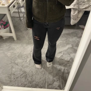 Svarta jeans från Vero Moda - Snygga svarta jeans från Vero Moda med slitna detaljer på knäna och bakfickorna. De har en klassisk femficksdesign och en bekväm passform. Perfekta för en avslappnad stil. (Hålen är gjorda själv och jeansen är nötta på vissa ställen)