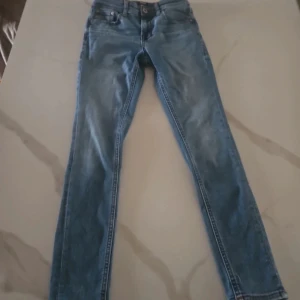 Blå jeans från Jack & Jones - Snygga blå jeans från Jack & Jones med klassisk femficksdesign. De har en knappgylf och är tillverkade i slitstarkt denim. Perfekta för en avslappnad stil.