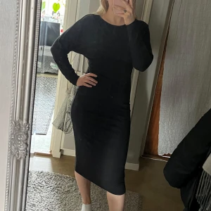 Mörkgrå långärmad klänning - Mörkgrå lång Jersey klänning i ett stretchigt material. Klänningen har långa ärmar, båtringning och en markerad midja. Strl S. Viskos blandning. 