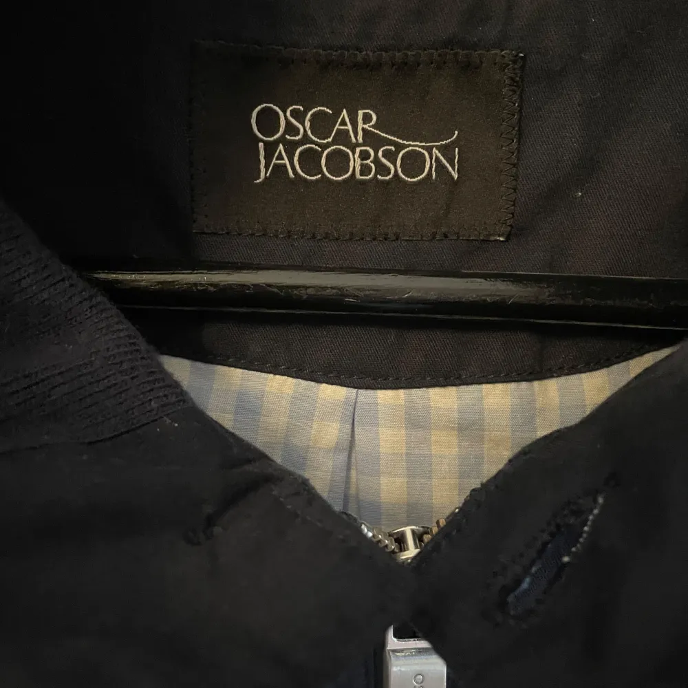 Snygg mörkblå jacka från Oscar Jacobson med dragkedja och broderad logga. Jackan har en stilren design med långa ärmar och ribbade detaljer vid ärmslut och nederkant. Perfekt för en stilren look.. Takit.
