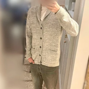 Cardigan | Grå - Steal 🚨| Cardigan från bläck | Super kvalitet, med detaljer som stickade detaljer runt fickorna | Grå, silvrig, sjukt snygg/lyxig nyanserad färg | Passar bra på mig ”185cm & 72 kg”, | Stl M | Skick 10/10 | Nypris 899:- | ‼️ Mitt pris 229 kr endast! ‼️ (sista bilden är för att visa prisklassen för liknande tröjer av samma märke)