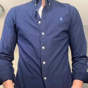 Mörkblå skjorta från Ralph Lauren - Snygg mörkblå skjorta från Ralph Lauren. Använd max 5 Gånger. Storlek M men är liten i storleken. 