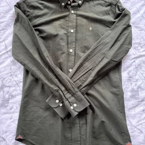 Grön skjorta från Morris - Mörkgrön/oliv färgad Morris skjorta i strl XS, men passar lika bra för strl S. Använt ett fåtal gånger, Säljs pga jag inte passar in i denna färg. Nypris: 1200kr. Mitt pris: 599. Kan diskuteras vid snabbaffär:)