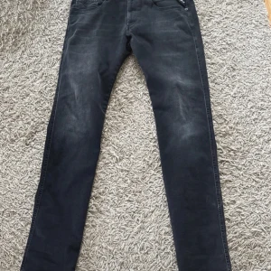 Svarta jeans från Replay Hyperflex - Snygga svarta jeans från Replay Hyperflex med en modern passform. De säljs pågrund av de var för små när jag fick dem därför är det ganska högt i pris. De har en klassisk femficksdesign och är tillverkade i ett stretchigt material för extra komfort. Perfekta för en stilren look. Pris kan diskuteras. 