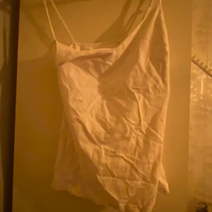 Vit linnetopp - Säljer en enkel och stilren vit linnetopp med smala axelband. Perfekt för varma dagar eller som ett basplagg i garderoben.