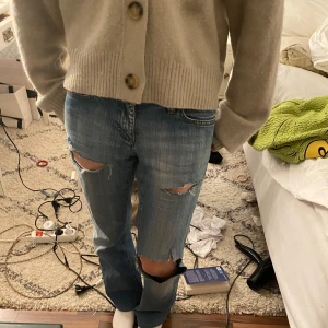 lågmidjade jeans - Snygga blå jeans med slitningar på knäna för en trendig look.  svin snygga fickor i bak!😍🔥midjemått: 37 cm, innerbenslängd: 72 cm💕går även att sprätta upp då jag har fått dom upplagda av en skräddare❤️