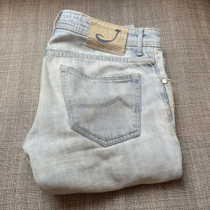 Jacob Cohën jeans - Säljer nu ett par snygga jeans från Jacob Cohën i den trendiga modellen 622. Tillverkade av högkvalitativt denim i Italien. Nypris över 5000kr. W31/L32 ish. Jeansen har snygga slitningar som är design. De är i använt skick, med ett litet hål i knät och små smutsfläckar nertill på byxan, inget som inte går att fixa, och märks ej vid användning. Hör gärna av er vid frågor eller fler bilder😁