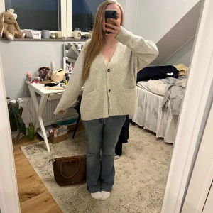 Beige kofta med knappar - Mysig beige kofta med stora knappar framtill. Den har en lös/stor passform och långa ärmar. Använd några gånger men är i ett bra skick! 