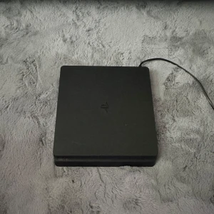 PlayStation 4 Slim med spel - Säljer en PlayStation 4 Slim med en handkontroll och fem spel: NBA 2K23, Call of Duty: Black Ops III, NFS Heat, FIFA 23 och Call of Duty: Modern Warfare. Perfekt för gamingkvällar! 🎮