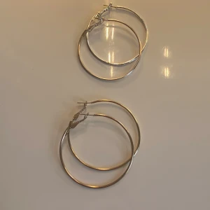 Silver och guld hoops - Säljer två par stora, stilrena hoop-örhängen i silver och guldfärg. Perfekta för att ge en elegant touch till din outfit. De har en enkel och klassisk design som passar till många olika stilar. 1 par för 10 o båda för 15.🥰