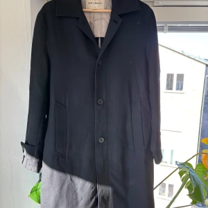 Our Legacy Car Coat Black Crepe Wool size 46 - Ursnygg svart rock från Our Legacy i lätt ullmaterial perfekt nu till våren! I använt men gott skick! Kan mötas i Sthlm och Uppsala!