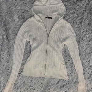 Vit stickad hoodie från Tommy Hilfiger - Vit stickad zip från Tommy Hilfiger med luva. Rätt tunn då den inte har något foder. Står storlek M men skulle säga att den passar S-L
