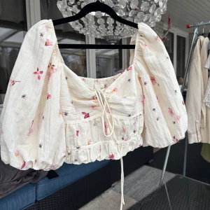 Blommig puffärmad blus - Charmig blommig blus med puffiga ärmar. Blusen har ett knytband framtill och ett elastiskt parti på baksidan för en bekväm passform. Perfekt för vår och sommar!🌸💕🌸💕aldrig använd