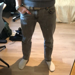 Grå jeans från Woodbird - Snygga grå jeans från Woodbird med en klassisk femficksdesign. De har en dragkedja och knapp framtill samt en läderpatch med logotypen på baksidan. Perfekt tillskott för garderoben!👍