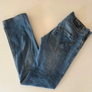 Dondup jeans  - Snygga blå jeans från Dondup med en slim passform. De har en lätt slitning för en avslappnad look. Storlek 32 med modellen GEORGE. Är 183 cm lång och väger 72kg. Skriv för fler bilder. 