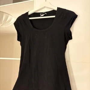 Svart kortärmad topp - Säljer en stilren svart topp med korta ärmar. Perfekt basplagg för garderoben. Hör av er vid funderingar eller om ni vill ha bilder med hur plagget sitter på mig. Titta gärna in mina andra plagg!