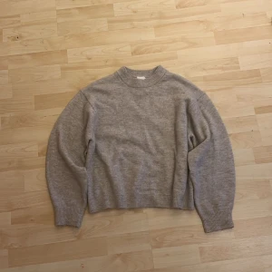 Beige stickad tröja - Säljer en mysig beige stickad tröja med ribbade muddar vid ärmslut och nederkant. Från HM. Perfekt för kyligare dagar och enkel att matcha med olika outfits.