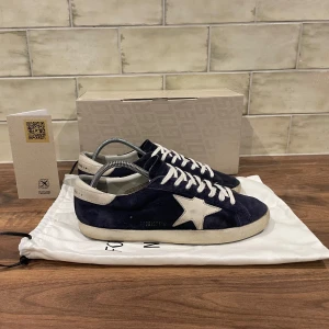 Golden Goose Sneakers Mocka Mörkblå - Golden Goose Skor | Skicket är 9/10 - Storlek 42 (passar 43 EU) Nypris 5699 - Vårt Pris 3099kr, skorna är i otroligt bra skick endast en väldigt  liten defekt på sulan annars i nyskick! ALLT OG ingår (äkthetsbevis, box, dustbag) Tveka inte vid att ställa frågor vid funderingar! 