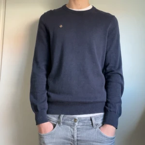 Mörkblå tröja från Morris - Säljer en stilren mörkblå tröja från Morris i storlek M. Tröjan har en liten broderad logga på bröstet och ribbstickad halsringning. Nypris ligger på 1200. Lägg ett bud eller köp direkt