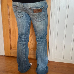 Bootcut jeans - Skitsnygga blåa lågmidjade bootcut jeans. Lite slitningar längst ner vid fötterna och har lagade hål. 